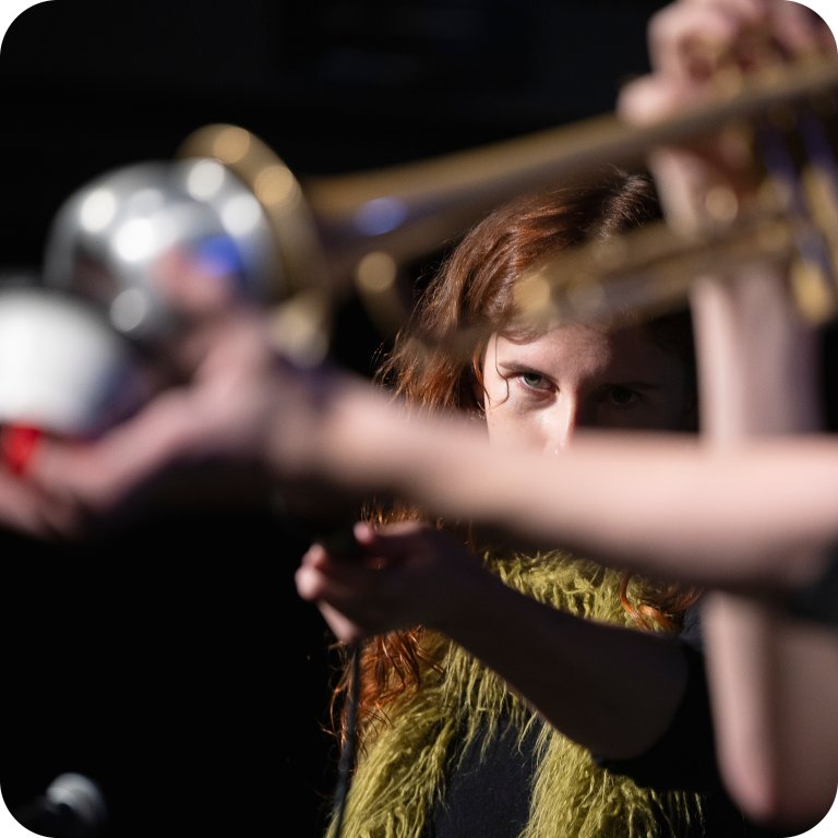 Vokalist ser mellom armene på en annen spillende student